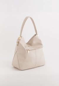 Beżowa skórzana torebka o miękkim, luźnym kształcie. Posiada zapinaną na zamek kieszeń z przodu oraz złote akcenty. Krótki uchwyt.