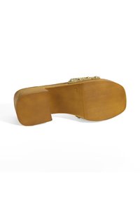 Braunes Holz-Plateau-Schuh mit einem strukturierten, gold-akzentuierten Riemen. Die Sohle ist breit und leicht gebogen mit einem flachen Rückteil für Stabilität.