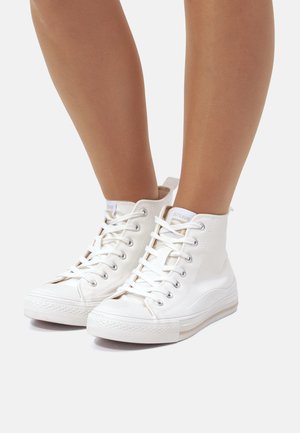 Weiße High-Top-Sneaker mit Schnürverschluss, Gummisohle und einem glatten Obermaterial aus Canvas. Mit einer kleinen Schlaufe auf der Rückseite für einfaches Anziehen.