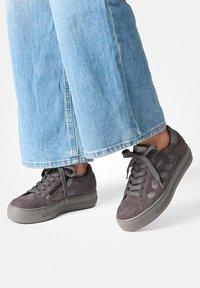 Baskets en suède gris avec une finition texturée, semelles plates et lacets assortis. Détail de fermeture éclair sur le côté et accents gris contrastants.