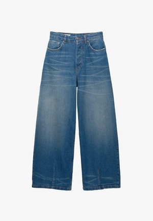 Jean large bleu avec poches avant, passants de ceinture, fermeture à bouton et détails de dégradé subtils sur les cuisses et les fentes d'ourlet.