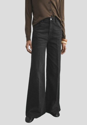 Wide-leg black denim jeans with a high waist and front pockets. Paired with a brown button-up shirt. Smooth texture and casual design.