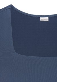 Top blu scuro con scollatura ampia e superficie morbida. Presenta un pannello in tessuto a contrasto. Etichetta con la scritta "LASCANA."