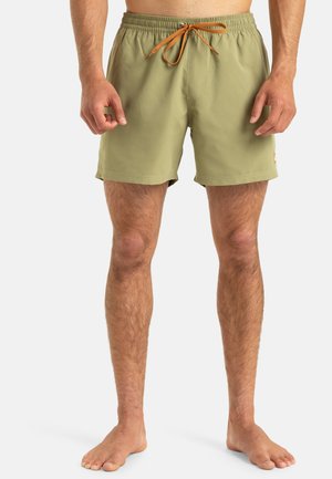 Șorturi de baie kaki cu un tiv elastic și un șnur portocaliu. Au buzunare laterale și un patch cu logo pe piciorul stâng.