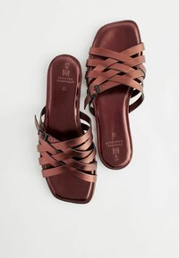 Brune faux læder slide sandaler har flere krydset remme, en firkantet tå og en polstret indersål med præget branding.