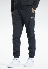 Schwarze athletische Jogginghosen aus leichtem Stoff, mit elastischem Bund und Bündchen, und Logodetail auf dem linken Oberschenkel.