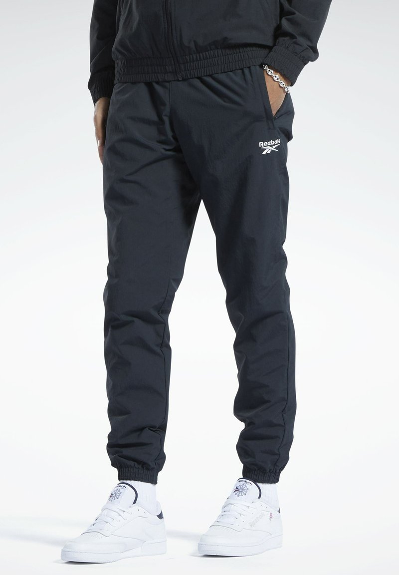 Schwarze athletische Jogginghosen aus leichtem Stoff, mit elastischem Bund und Bündchen, und Logodetail auf dem linken Oberschenkel.