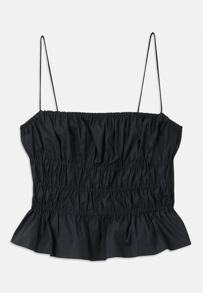 Black crop top featuring elastic ruching throughout, thin adjustable straps, and a ruffled hemline; made from a smooth textile.
