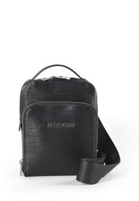 Crna pravokutna torbica s remenom za crossbody s teksturiranom površinom, gornjom drškom i podesivim remenom. Ima glavnu pregradu sa zatvaračem i prednji džep.