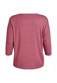 Loose-fit mauve long-sleeve shirt with a wide round neckline shown from the back on a white background.