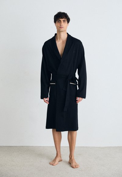 Peignoir noir avec col châle et lien à la taille, fabriqué en tissu doux. Dispose de manches longues et de détails d'accent subtils.