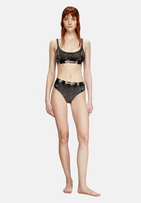 Set di lingerie nero con un bralette a spalline sottili e slip a vita alta abbinati, entrambi con una texture morbida e un bordo a contrasto.