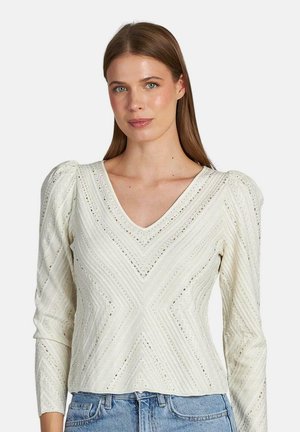Top de punto blanco con escote en V, mangas largas y patrones en chevrón texturizados. Presenta hombros abullonados y un ajuste ligeramente corto.