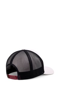 Cappellino da baseball bianco con retro in rete nera e chiusura a scatto regolabile di un rosso scuro, posato piatto su una superficie bianca.