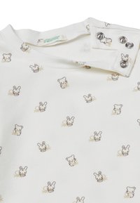 Biała koszula z powtarzającym się wzorem małych, kreskówkowych misiów i królików. Bawełnowy materiał, okrągły dekolt z zapięciem na napy.
