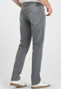Jeans de mezclilla gris con corte recto, que cuentan con cinco bolsillos, un ligero desvanecimiento y una etiqueta de marca de cuero negro en la parte trasera de la cintura.