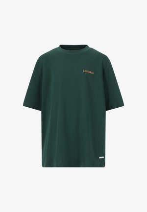 Grøn bomulds T-shirt med teksten "LES ARCS", parret med sorte shorts, sorte sokker og sorte sneakers. Mand står med hånden i lommen.