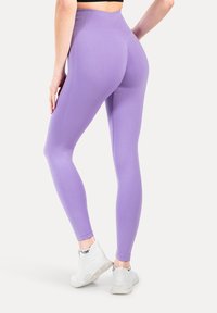 Paarse legging met een hoge tailleband, textuurpatroon en een aansluitend ontwerp. Draagt met witte sneakers, voorzien van een gevoerde zool.