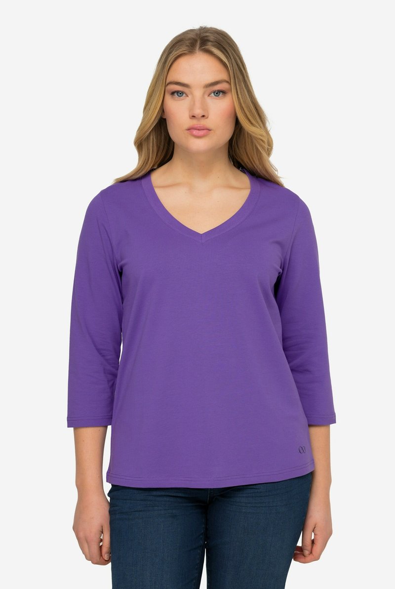 Lila Langarm-V-Ausschnitt-Shirt aus weichem Stoff mit lässiger Passform, das einen dezenten Logoakzent am Saum und eine standardmäßige Ärmel-Länge aufweist.