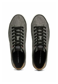 Gray fabric sneakers with black laces, white soles, and a brown accent near the heel. The interior features a black branded insole.