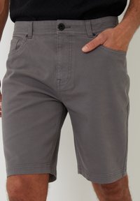 Grå shorts lavet af en bomuldsblanding, med en enkelt knaplukning, bæltestropper og sidelommer. Minimalistisk design med syninger.