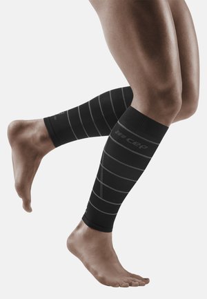 Schwarze Kompressionsbeinschläuche mit grauen Streifen, die ein angepasstes Design und elastisches Material aufweisen und die Unterschenkel und Knöchel bedecken.