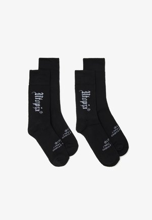 Calcetines de algodón negros con puños acanalados, que presentan texto de logo blanco en el costado y la suela. Diseño clásico con una textura suave.