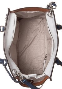 Bolso de mano blanco de cuero abierto con un forro de tela beige con patrones, cierres metálicos, bolsillos con cremallera y acentos de correa azul.