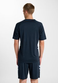 Granatowa sportowa koszulka z krótkim rękawem, gładką fakturą i wzorem bocznych pasków. Dopasowana do niej para szortów, zaprojektowana do aktywnego noszenia.