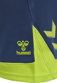 Shorts sportivi navy e verde neon realizzati in materiale traspirante, con finitura testurizzata, un logo e dettagli a zigzag.