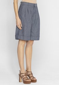 Niebieskie, spodenki do kolan z fałdami z przodu, wykonane z lekkiego materiału. Posiadają prosty krój i podwinięty brzeg.