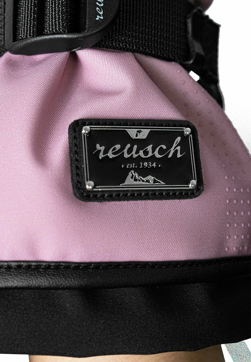 Reusch pink Sporthandschuh aus einem strukturierten Stoff, mit schwarzen Akzenten und einem silbernen Logoschild, das Berge und das Gründungsjahr zeigt.
