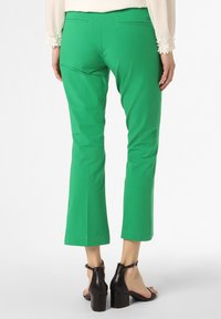 Groene, getailleerde broeken van gladde stof, met een cropped lengte en eenvoudig zakontwerp. Draag ze met zwarte block-heeled sandalen.