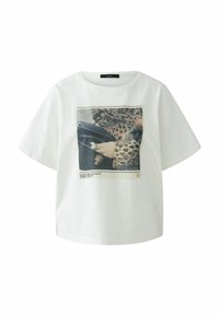 Witte katoenen t-shirt met korte mouwen, voorzien van een bedrukt ontwerp van een hand met sieraden die een zwarte tas vasthoudt, met dierenprintaccenten.