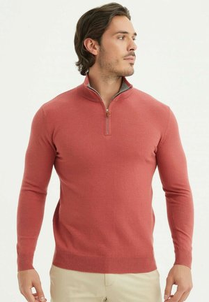 Pull en corail à col zippé, en tissu côtelé. Présente des manches longues et une couche intérieure contrastante au niveau du col. Design ajusté.