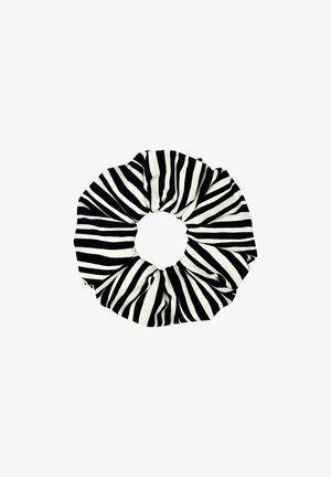 Czarnobiały scrunchie z materiału w paski zebry, skręcony w kształt koła na białym tle.