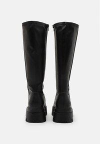 Black leather knee-high boots with a smooth finish, featuring a zipper closure and thick sole with tread detailing.