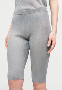 Γκρίζα ριμπ ποδηλατικά σορτς με εφαρμοστή σχεδίαση, διαθέτοντας ελαστική μέση και μήκος μέχρι το μέσο του μηρού. Η υφή είναι απαλή και ελαστική.