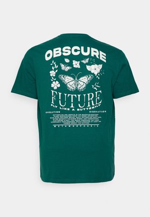 Teal katoenen t-shirt met witte grafische tekst en vlinderillustraties op de achterkant. Bevat bloemmotieven en verschillende typografiestijlen.