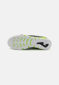Basket noir avec une tige texturée, présentant une semelle en caoutchouc blanche et verte avec un motif en chevron et un détail de logo.