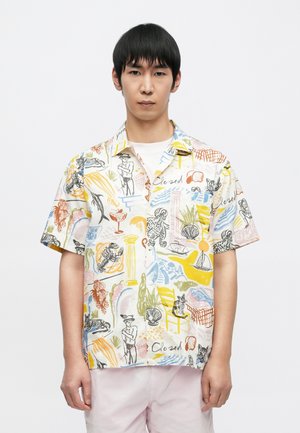 Chemise à manches courtes avec col, fabriquée en tissu léger, présentant un motif abstrait coloré avec diverses illustrations et formes.