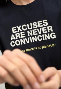 Tmavě modré bavlněné tričko s velkým bílým textem "VÝMLUVY NIKDY NEJSOU PŘESVĚDČIVÉ" a menším žlutým textem níže.