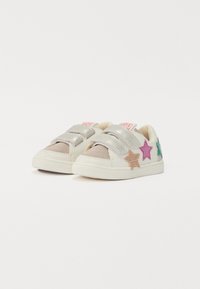 Hvite sneakers med metalliske sølvstropper, som har fargerike glitrende stjerneaksenter i rosa, grønn og gull på sidene.