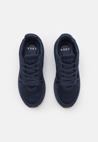 Marinblå träningsskor i mesh och mocka, med vadderad krage, snören och en räfflad gummisula.