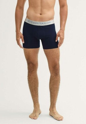 Marineblaue Boxer Shorts aus weichem Material mit einem grauen TOM TAILOR Logo-Bund, mit einer figurschmeichelnden Passform und einer Länge bis zur Mitte des Oberschenkels.