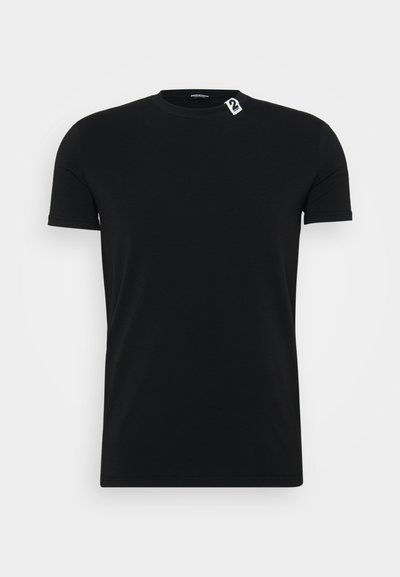 T-shirt nera in cotone con un classico scollo rotondo, maniche corte e un piccolo dettaglio in bianco sull'etichetta del collo.