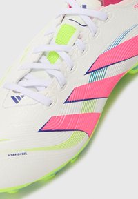 Witte voetbalschoenen met roze, groene en blauwe accenten. Genopte leren bovenkant, gaasdetails en hybride gevoelstechnologie.