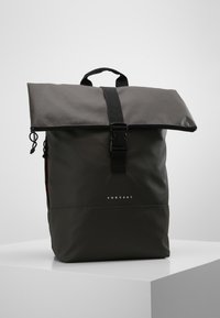 Gray waterproof backpack with a roll-top design, black strap, and buckle closure. Features a logo on the front and side pockets.