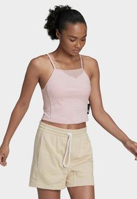 Top de tirantes finos de color rosa con canalé, combinado con pantalones cortos beige de cuerda. Ambas prendas presentan un diseño y textura casual y relajada.