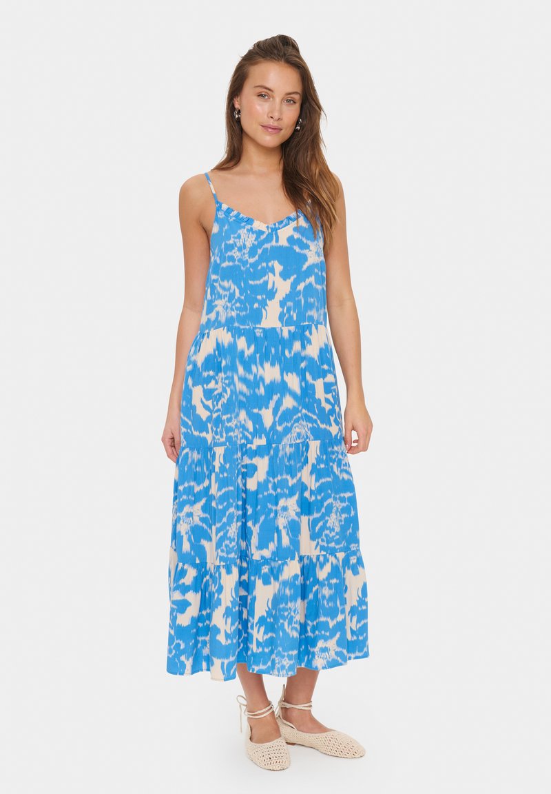 Mėlyna pieštinė maxi suknelė su spaghetti petnešėlėmis, turinti sluoksniuotą dizainą ir laisvą siluetą. Minkšta medžiaga su vidutiniu tekstūros lygiu.